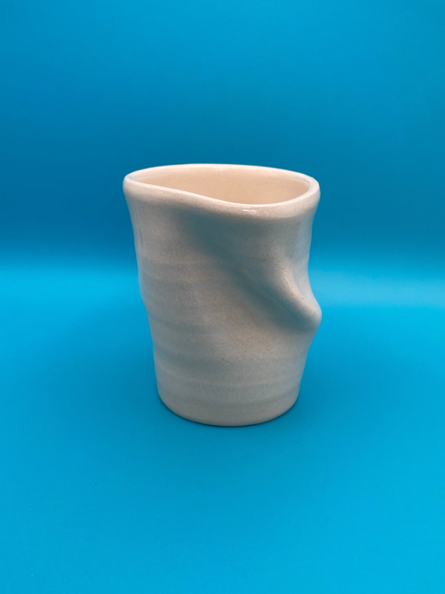 Non Paper Cup Crush – hand-thrown ceramic coffee cup with a crushed shape, made from stoneware clay and glazed with a transparent glaze