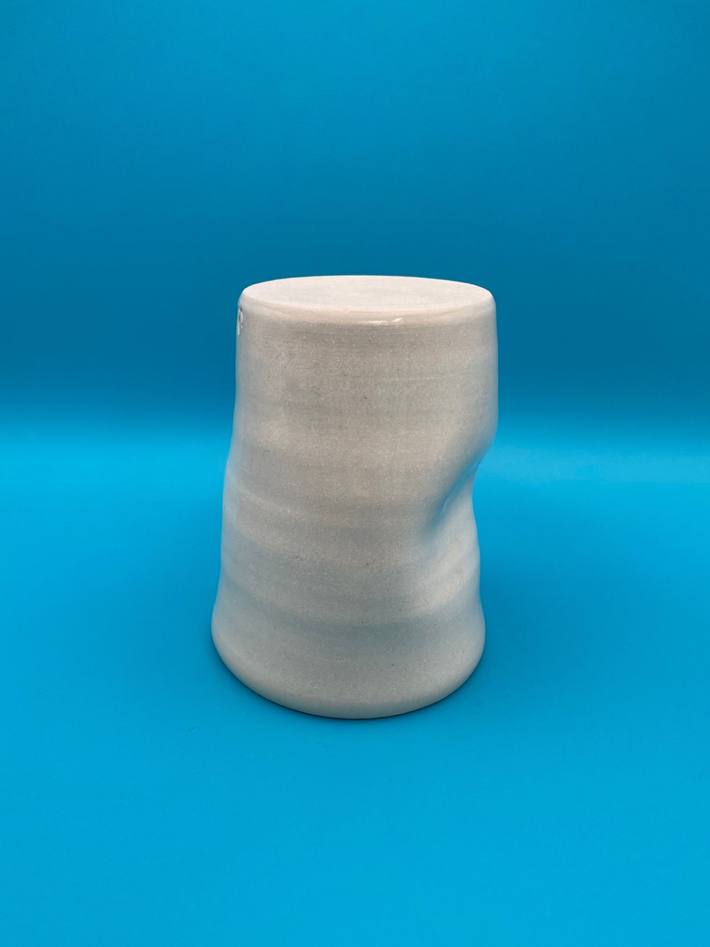Non Paper Cup Crush – hand-thrown ceramic coffee cup with a crushed shape, made from stoneware clay and glazed with a transparent glaze, shown upside down