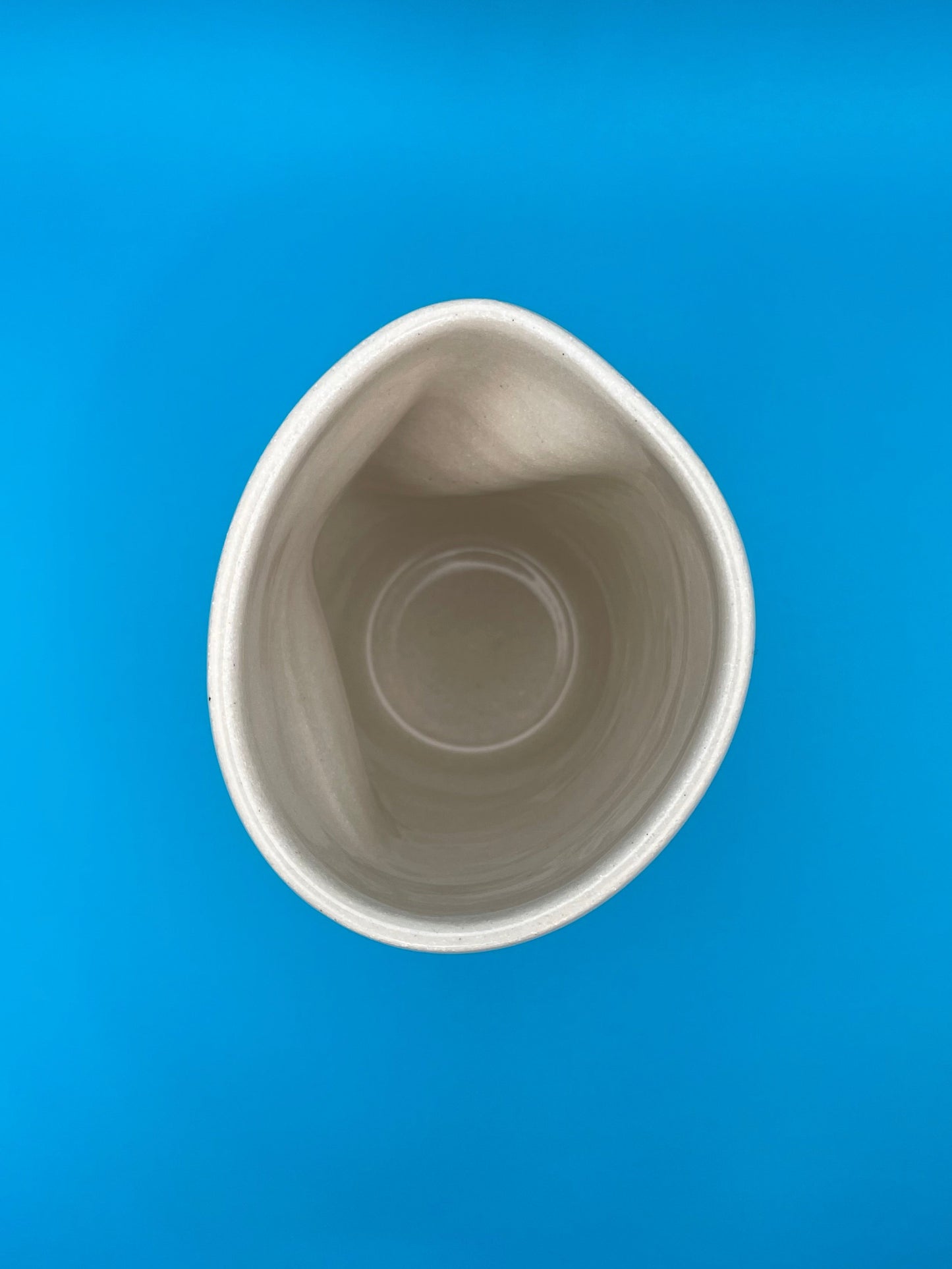 Non Paper Cup Crush – hand-thrown ceramic coffee cup with a crushed shape, made from stoneware clay and glazed with a transparent glaze, shown from above, looking inside