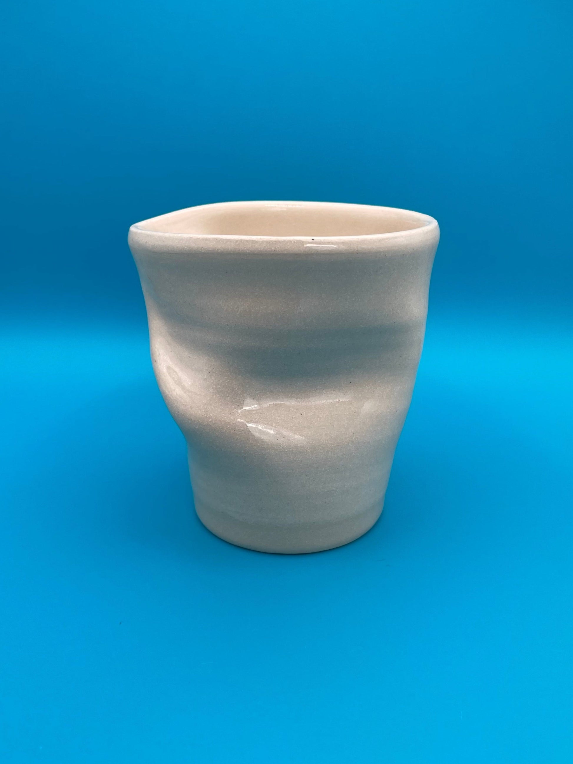 Non Paper Cup Crush – hand-thrown ceramic coffee cup with a crushed shape, made from stoneware clay and glazed with a transparent glaze
