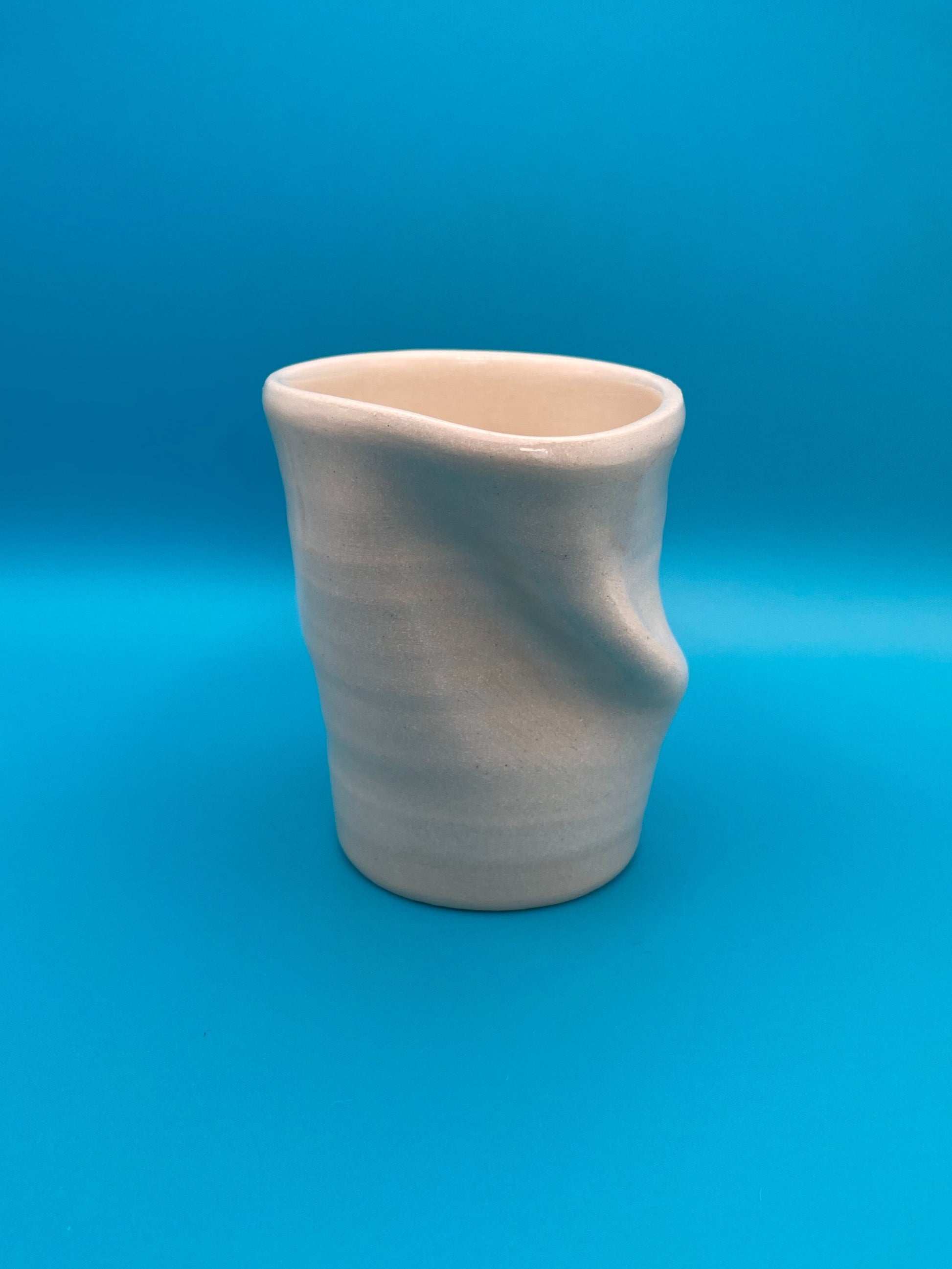 Non Paper Cup Crush – hand-thrown ceramic coffee cup with a crushed shape, made from stoneware clay and glazed with a transparent glaze