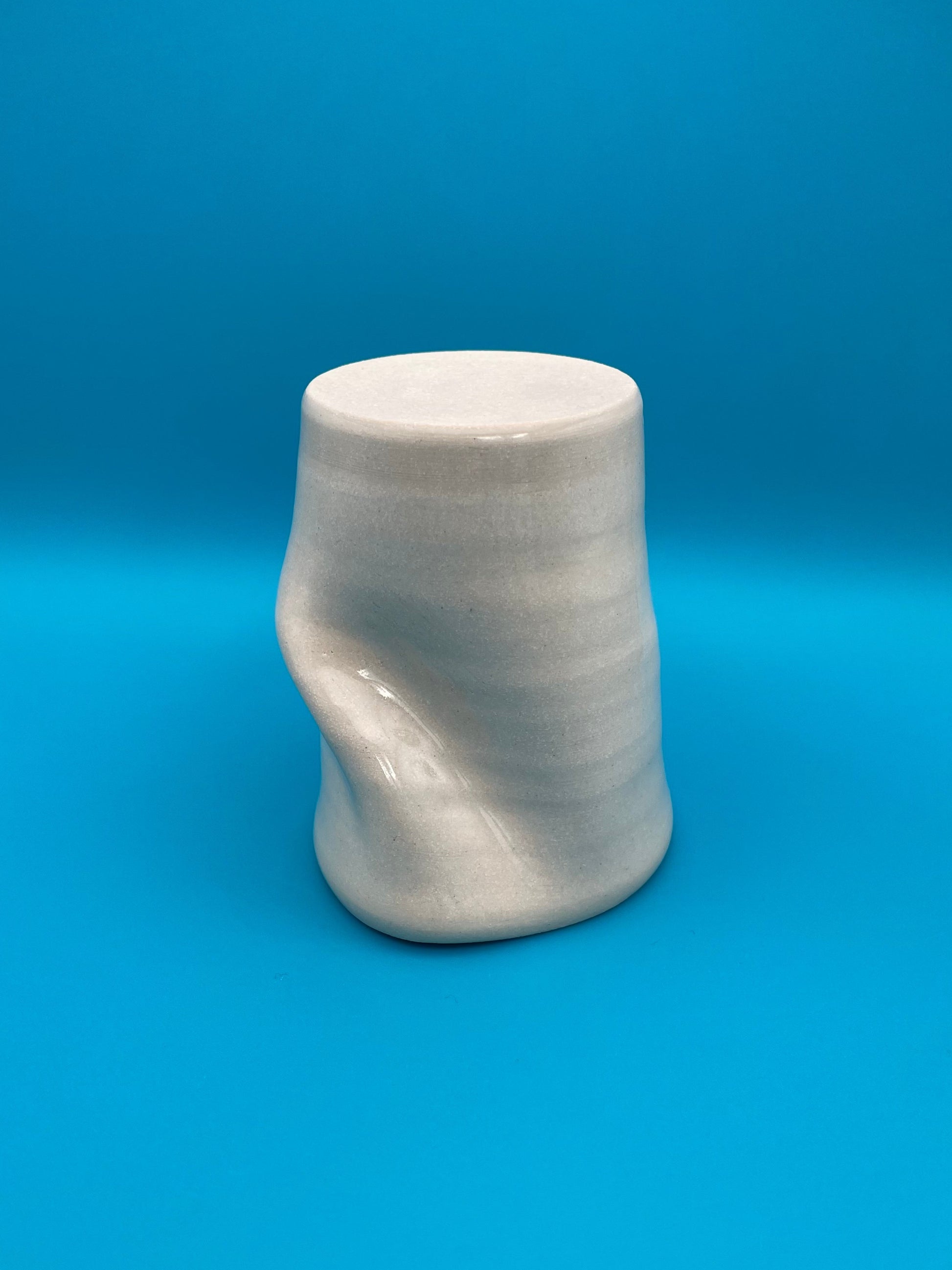 Non Paper Cup Crush – hand-thrown ceramic coffee cup with a crushed shape, made from stoneware clay and glazed with a transparent glaze, shown upside down