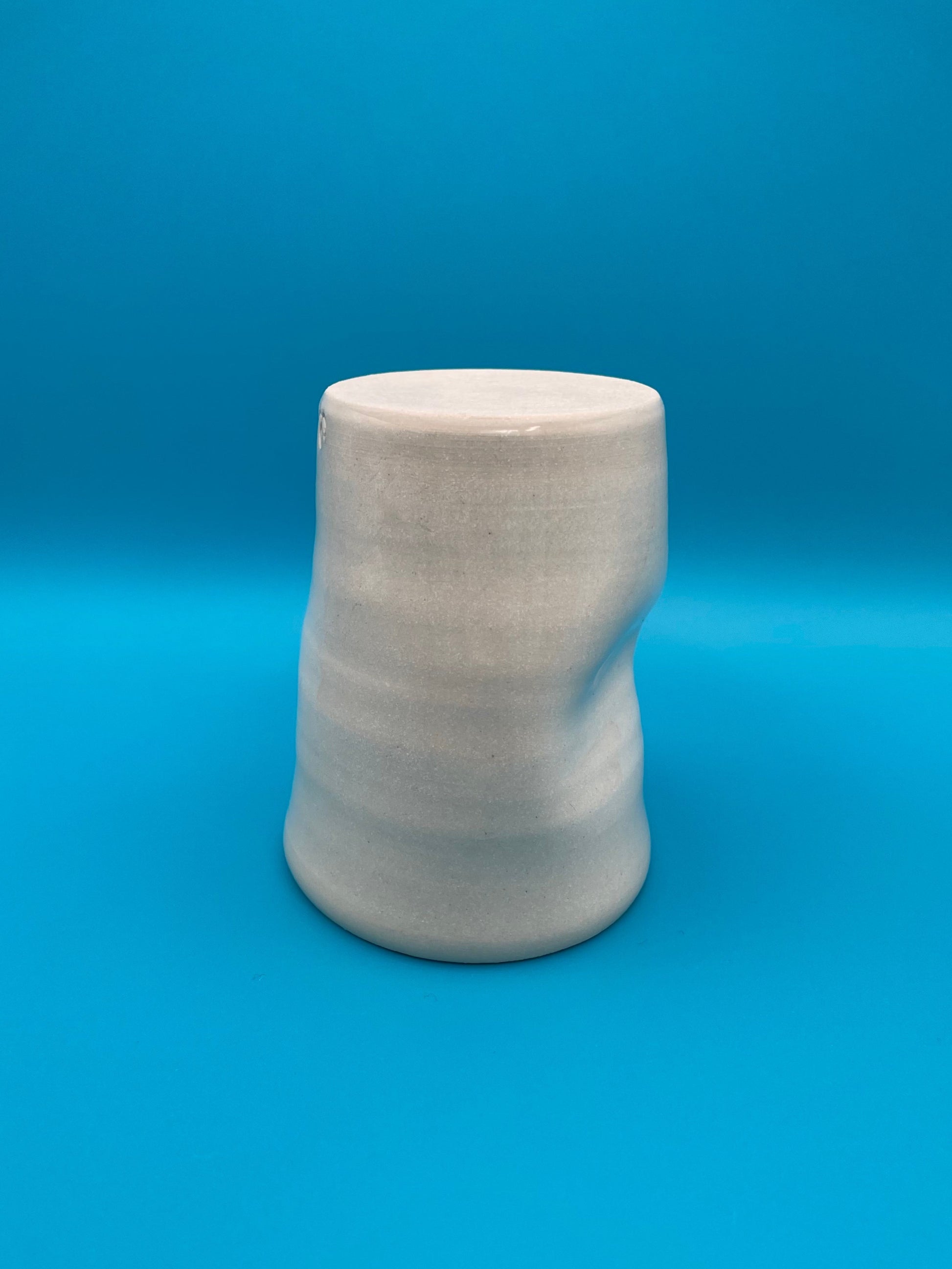 Non Paper Cup Crush – hand-thrown ceramic coffee cup with a crushed shape, made from stoneware clay and glazed with a transparent glaze, shown upside down