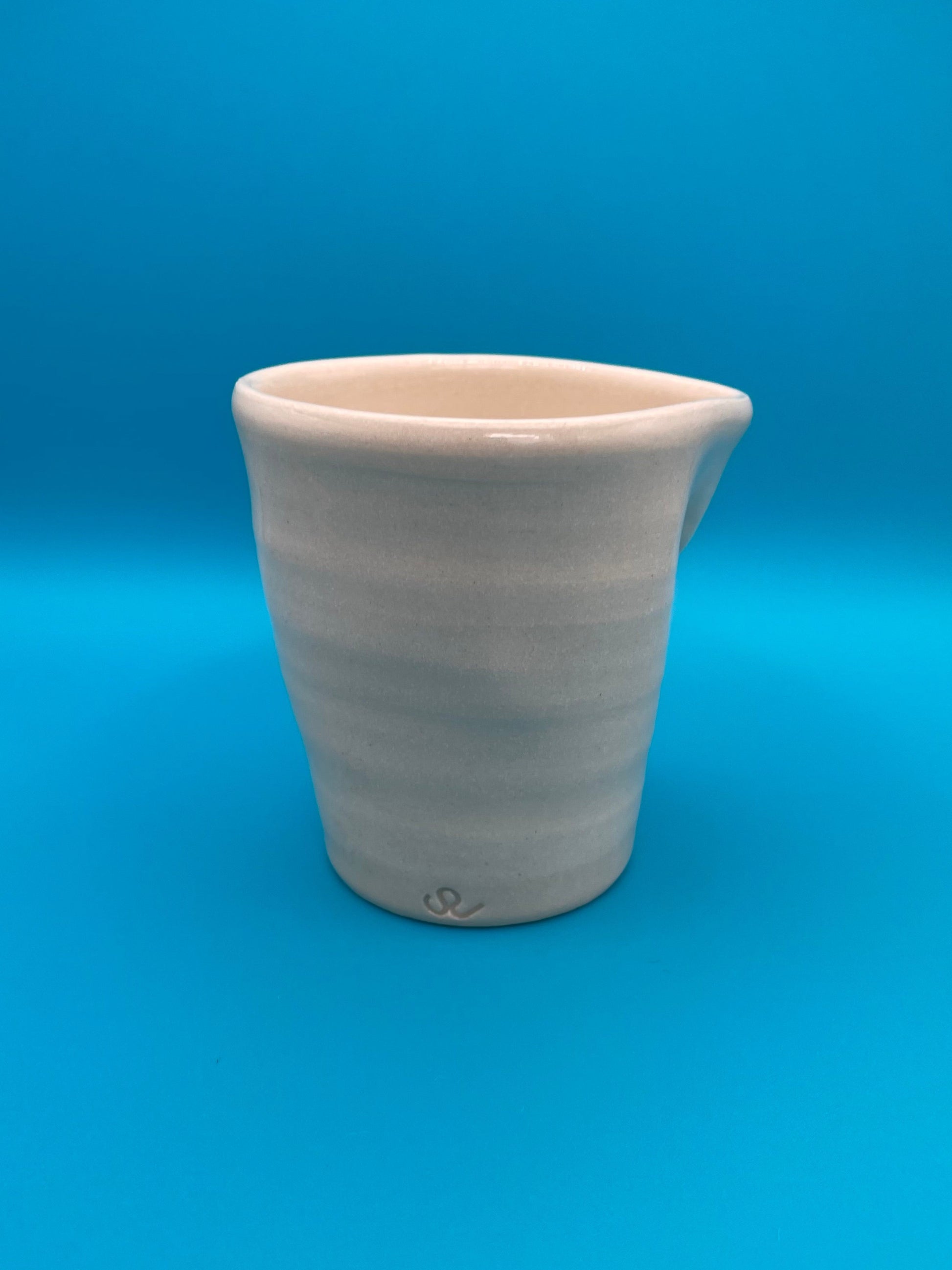Non Paper Cup Crush – hand-thrown ceramic coffee cup with a crushed shape, made from stoneware clay and glazed with a transparent glaze, S J Ceramic logo
